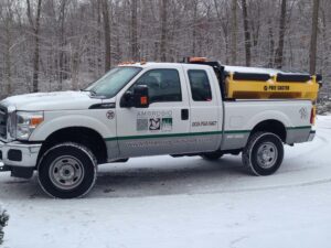 An Ambrosio Landscape Solutions snow plow truck on the road after a snow storm