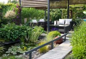 A modern furnished patio and pergola with a small pond, water lilys, hostas and Clematis; Design Tips for a Tranquil Outdoor Space
