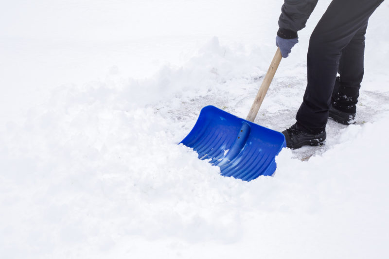 Man shoveling mound of snow