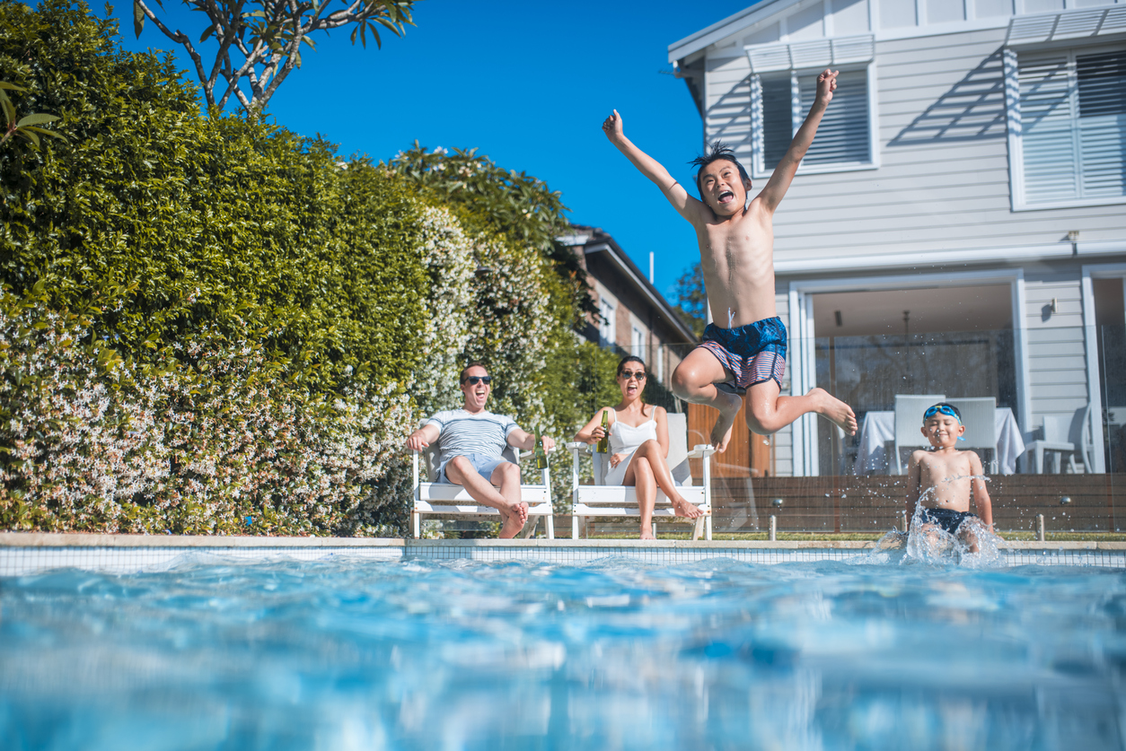 kid jumping into a swimming pool outside