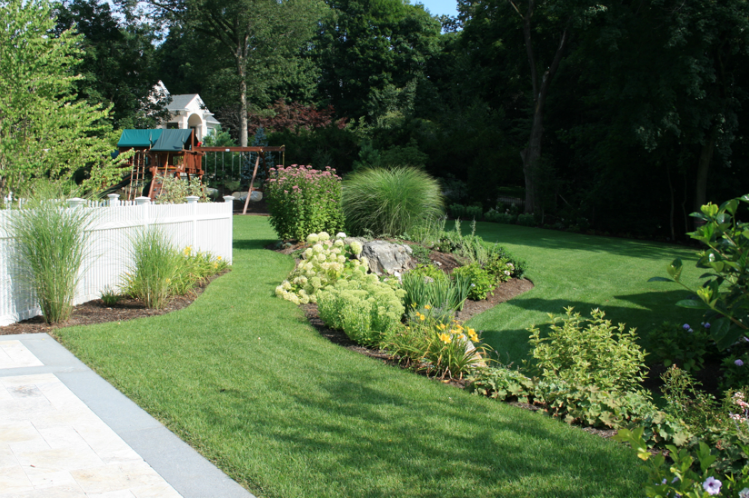 Backyard landscaping with several rocks and flowers