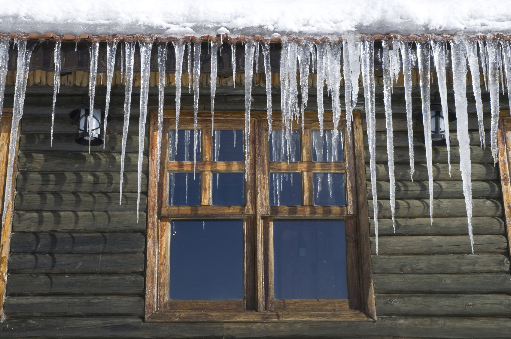 Icicles forming on log cabin roof