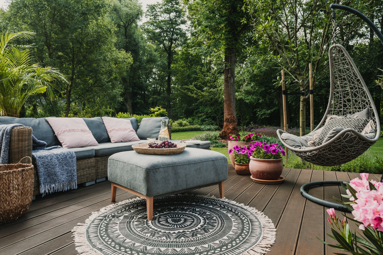 Garden patio decorated with Scandinavian wicker sofa and coffee table