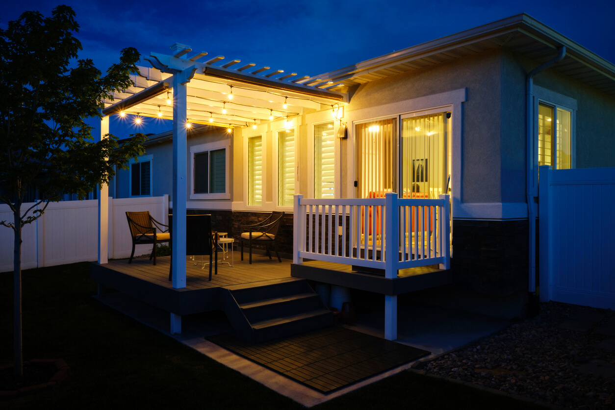 A backyard of a suburban USA home with a deck and pergola.