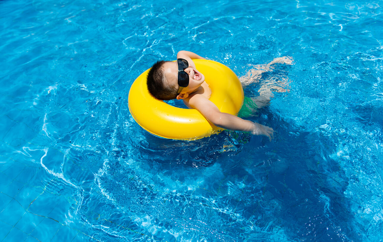 Little boy swimming at pool.