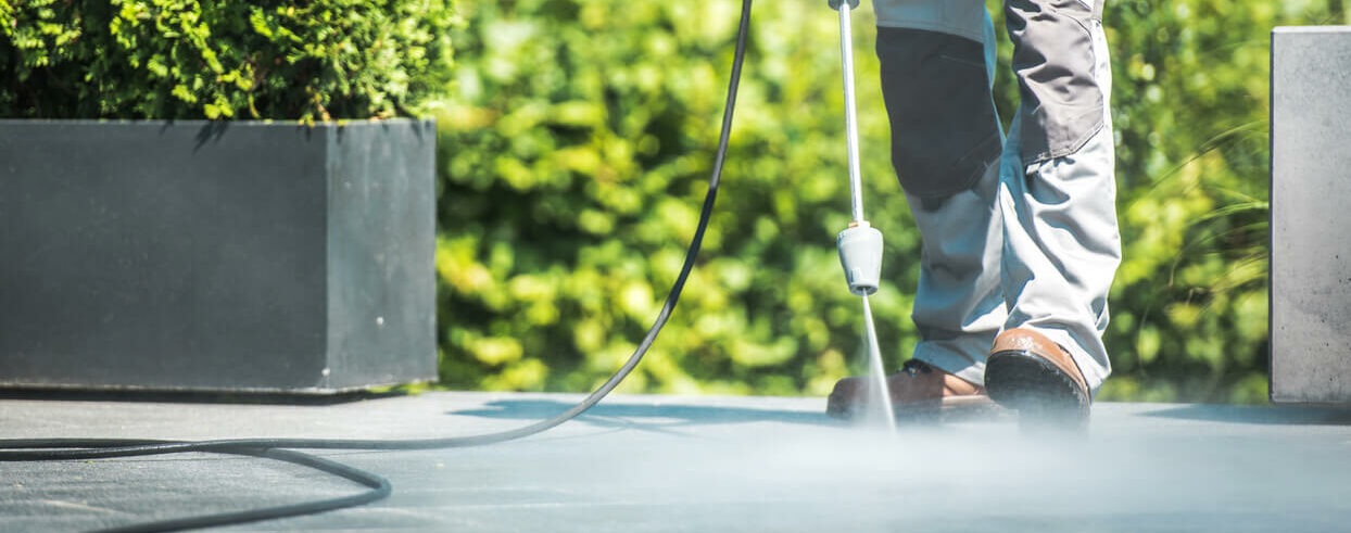 Patio Pressure Cleaning. Caucasian Men Washing His Concrete Floor Patio Using High Pressured Water Cleaner.