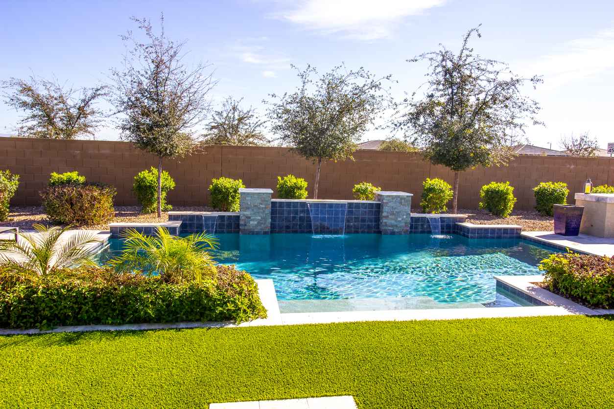 Modern Swimming Pool With Waterfalls In Back Yard