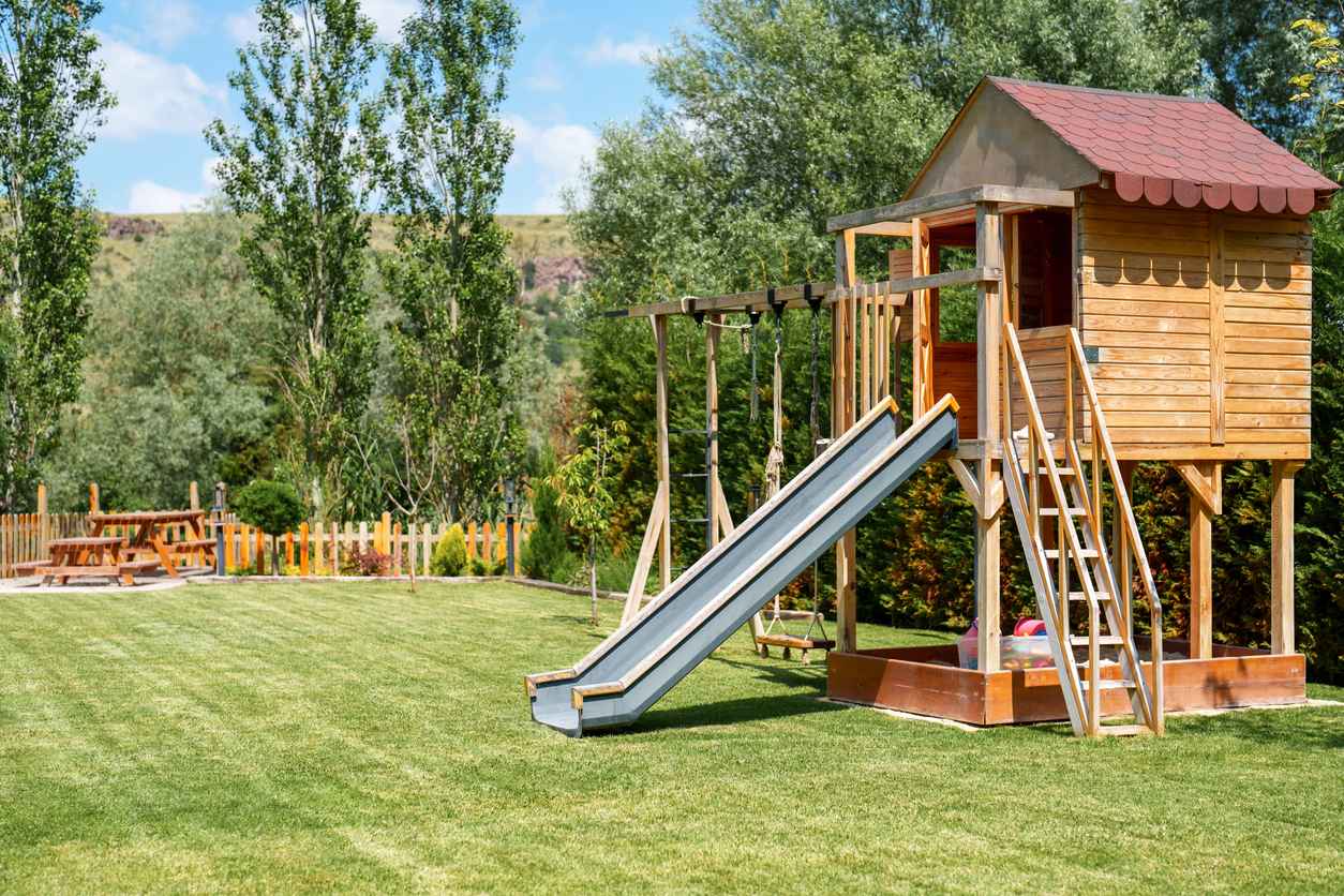 Kids playground set in a backyard on a bright summer day; Kid-Friendly Backyard Ideas