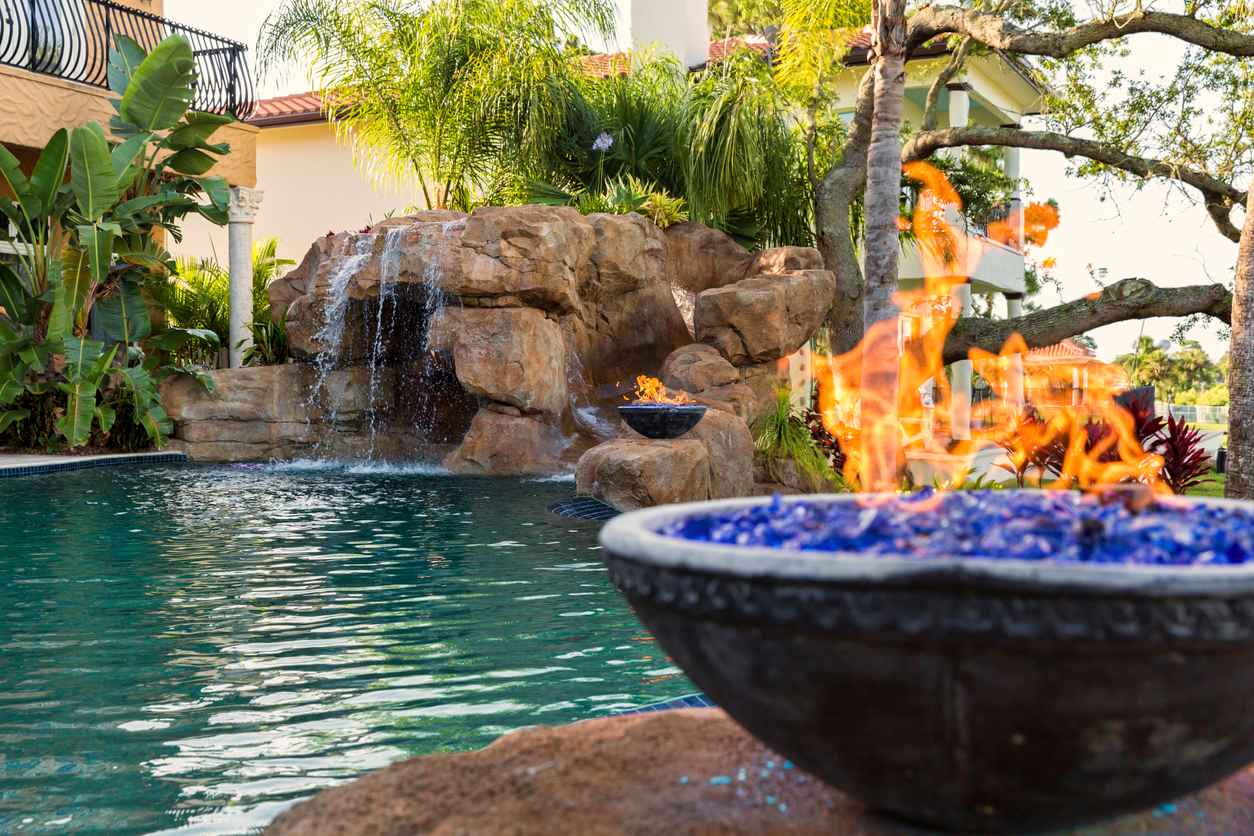 A fire pots and water fall highlight the many features of the custom pool.