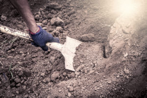 Shovel digging into dirt