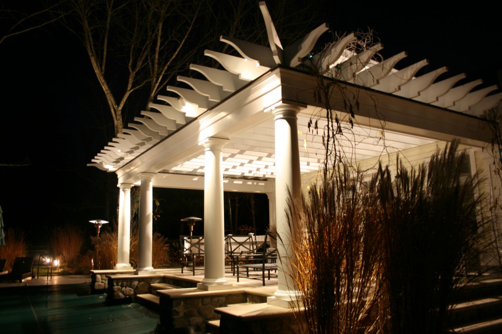 Columns of pool house lit up at night by lights
